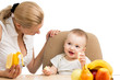 mother spoon feeding baby boy
