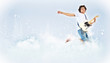 Photo: young man playing on electro guitar and jumping young man playing on electro guitar and jumping
