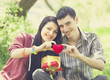 Couple with gift at green grass