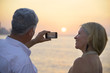 Foto: Senior man and woman using mobile phone to take photo Senior man and woman using mobile phone to take photo