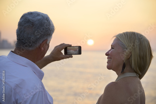 Photo: Senior man and woman using mobile phone to take photo Senior man and woman using mobile phone to take photo