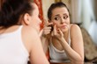 .Woman finding an acne on her cheek