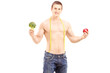 Fit young man holding a fruit and a vegetable