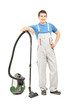 Full length portrait of a man in uniform posing with a vacuum cl
