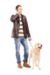 Photo: Full length portrait of a young man walking a dog and talking on Full length portrait of a young man walking a dog and talking on