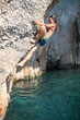 Deep water soloing, young female rock climber on cliff