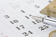ink pen and coin money on calendar