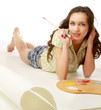 A young girl with a palette lying on the floor
