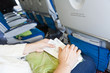 Photo: Female sitting in aircraft with boarding passes in hands Female sitting in aircraft with boarding passes in hands