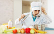 Caucasian handsome cook tasting veggie soup
