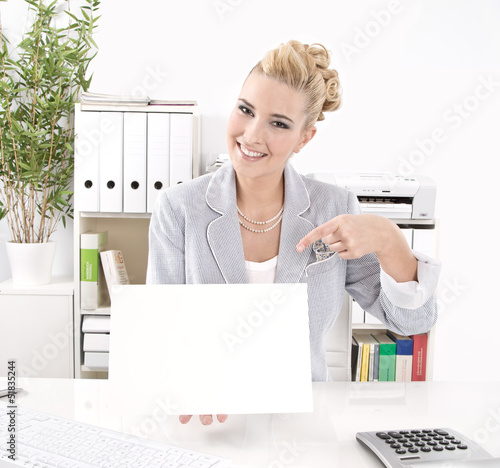 Photo: Blonde Geschäftsfrau mit einem Schild in der Hand Blonde Geschäftsfrau mit einem Schild in der Hand