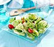 Garden salad with fresh vegetables on glass plate.