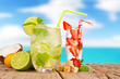 Fresh summer drinks on wooden table with blur sea background