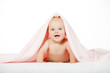 Foto: Caucasian baby boy covered with pink towel joyfully smiles at ca Caucasian baby boy covered with pink towel joyfully smiles at ca