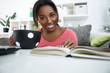 Photo: Smiling African student learning at home Smiling African student learning at home