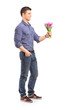 Full length portrait of a smiling guy holding flowers