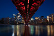Calgary skyline and pedestrian bridge at night.