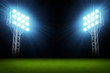 Green soccer field, bright spotlights, illuminated stadium