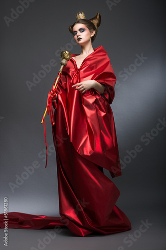 Photo: Magic. Woman Wizard in Red Pallium with Scepter. Witchcraft Magic. Woman Wizard in Red Pallium with Scepter. Witchcraft