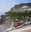 Fishing boats on slipway below lush green cliffs