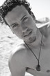 Portrait of a handsome young man with a goatee on the beach