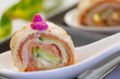 Photo: Smock salmon rolls with cucumber and crème fresh on white servi Smock salmon rolls with cucumber and crème fresh on white servi