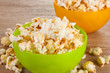 popcorn in bright plastic bowls on wooden table