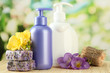 Liquid and hand-made soaps on wooden table, on green background