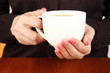 Hands holding mug of hot drink, close-up