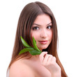 Beautiful young woman with green leafs isolated on white