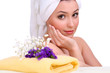 Beautiful young woman with flowers and towel