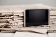Pile of newspapers with smartphone on it