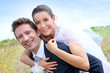 Groom giving pigguback ride to bride