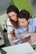Photo: Couple at home sitting in front of laptop Couple at home sitting in front of laptop