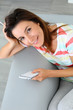 Upper view of woman in sofa using smartphone