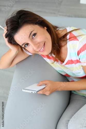 Photo: Upper view of woman in sofa using smartphone Upper view of woman in sofa using smartphone