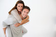 Handsome guy giving piggyback ride to girlfriend