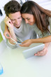 Cheerful couple looking at internet on tablet