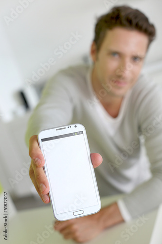 Photo: Closeup on smartphone screen held by man's hand Closeup on smartphone screen held by man's hand