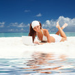 Photo: Cute woman with white laptop on the summer beach Cute woman with white laptop on the summer beach