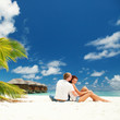 Photo: happy couple kissing in the sunny beach happy couple kissing in the sunny beach