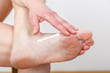 A woman putting cream on her foot