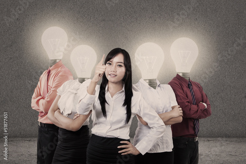 Photo: Businesswoman and team with light bulb heads Businesswoman and team with light bulb heads