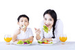 Photo: Mother and son eating healthy salad - isolated Mother and son eating healthy salad - isolated