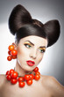 Portrait of sensual woman model with luxury makeup with tomatoes