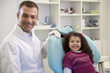 Portrait of child and dentist in dental studio, looking at camer