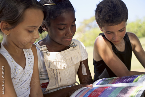 Photo: Children and education, kids and girls reading book in park Children and education, kids and girls reading book in park