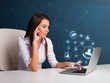 Young lady sitting at desk and typing on laptop with social netw