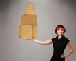 Photo: Young lady holding a set of brown cardboard boxes Young lady holding a set of brown cardboard boxes