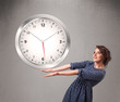 Attractive lady holding a huge clock